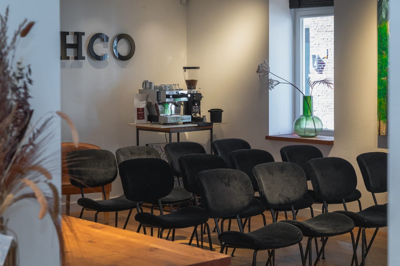 Zicht op de zaalopstelling met de espressomachine op de achtergrond