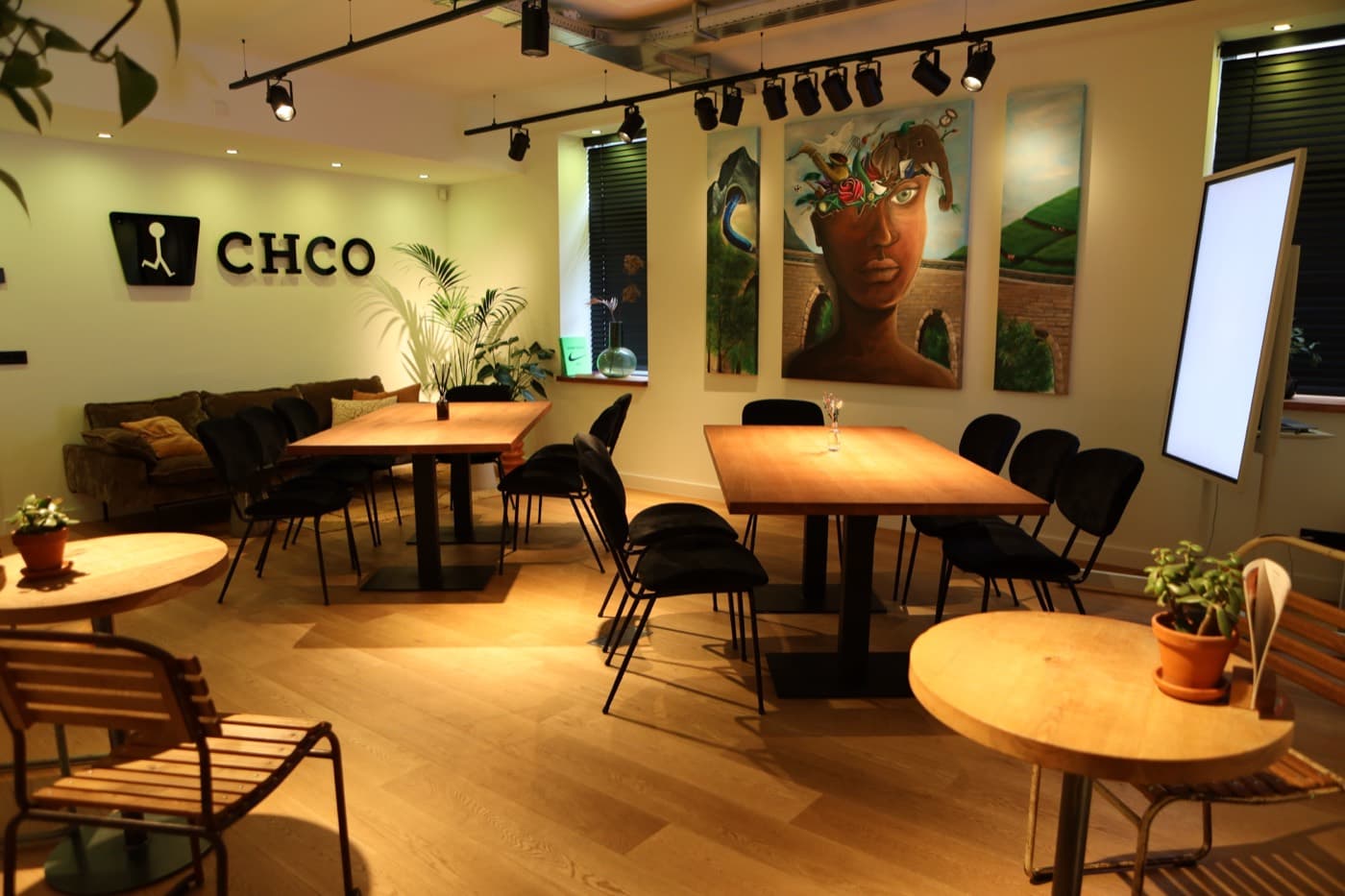 De Business Lounge met vergadertafels, presentatiescherm en loungebank