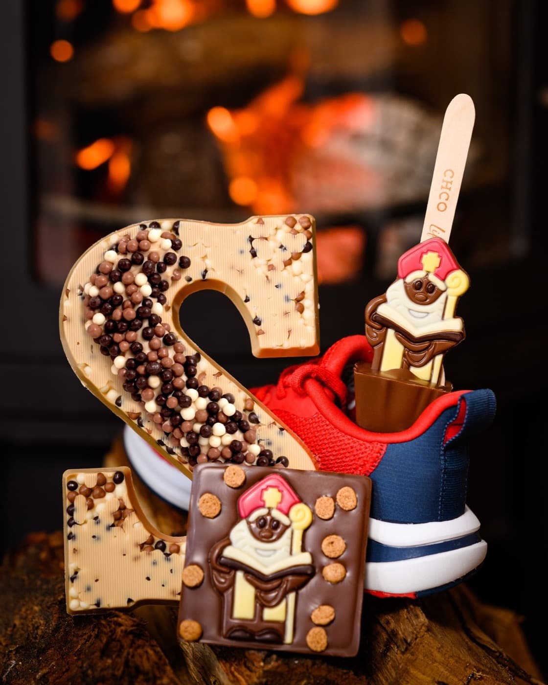 Chocoladeletter, sinterklaasreep en hotchocspoon bij een open haard